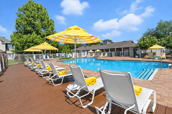 A poolside area with sun loungers and umbrellas.